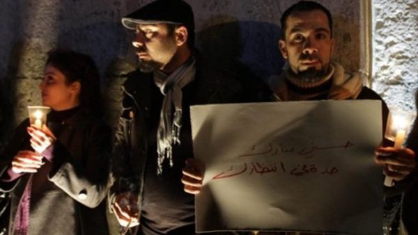 سوريون يوقدون الشموع في منطقة باب توما بدمشق تضامنا مع المصريين/أ.ف.ب