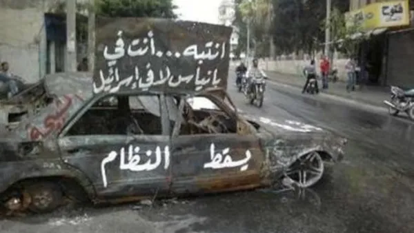 سيارة محترقة في بانياس وعليها شعارات تطالب باسقاط النظام