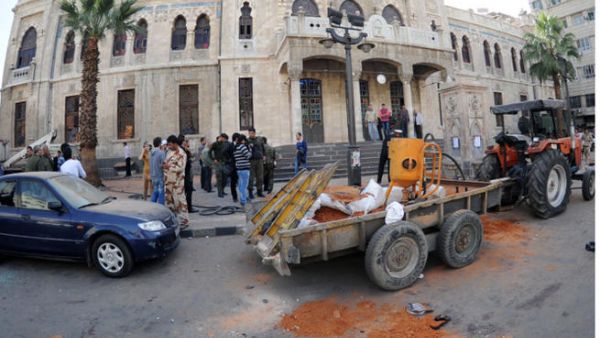 A handout picture released by the official Syrian Arab News Agency (SANA) shows people gathering outside the entrance to the Hijaz railroad company in Hijaz square. (Image credit: AFP)