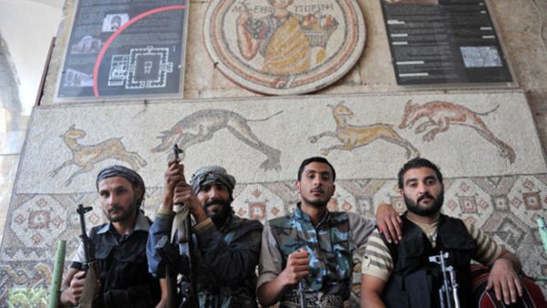 Syrian opposition fighters pose in front of a mosaic at the now heavily damaged museum in the rebel-held town of Maaret al-Numan.  (AFP/Bulent Kilic)