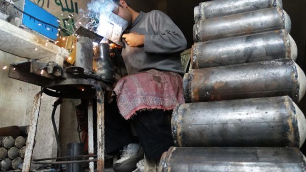 A rebel fighter prepares improvised mortar shells at a workshop in Syria. (Image credit: AFP)