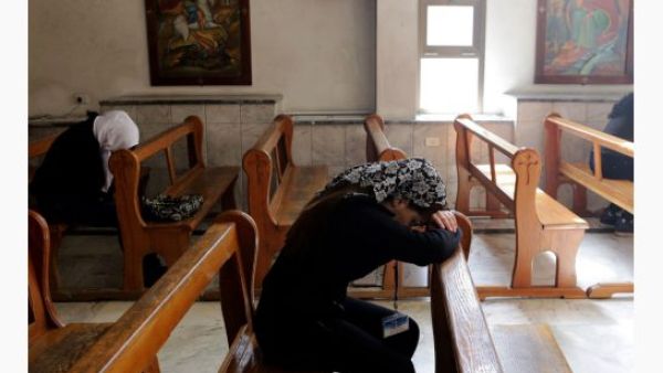 Women pray in a church in Syria. A Syriac Catholic priest was kidnapped along with a companion near Qaryatayn, in Homs governorate, says an NGO. (AFP/Louai Beshara)