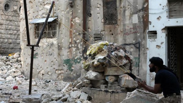 A Syrian opposition fighter aims fire with a catapult towards regime forces in the northern embattled Syrian city of Aleppo. (Image credit: AFP)