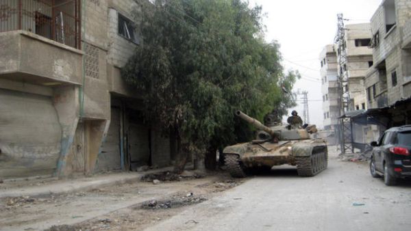A picture taken on November 7, 2013, shows a pro-regime tank driving through the streets of Sbeineh south of Syrian capital Damascus. (Image credit: AFP)