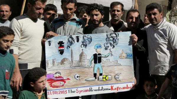 Syrian anti-government protestors hold a poster depicting a inspector from the Organisation for the Prohibition of Chemical Weapons (OPCW). (Image credit: AFP)