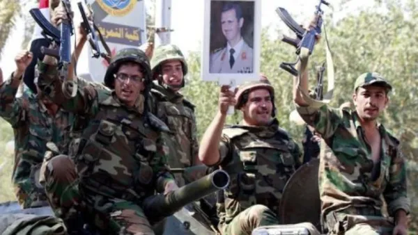 عناصر من الجيش السوري يرفعون صورة للرئيس الأسد