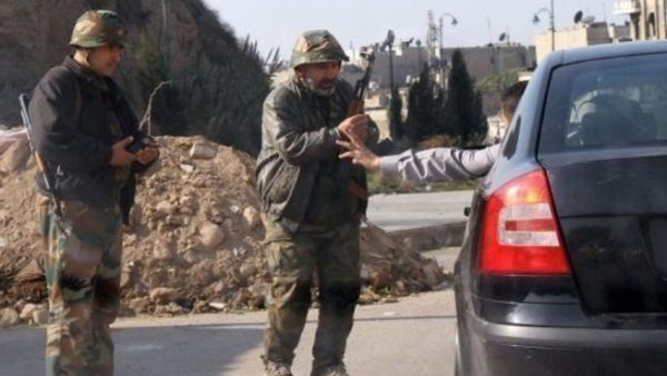 عنصران من الجيش السوري على أحد نقاط التفتيش