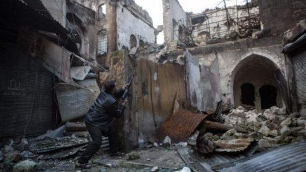 A Syrian rebel takes aim amid destruction (AFP)