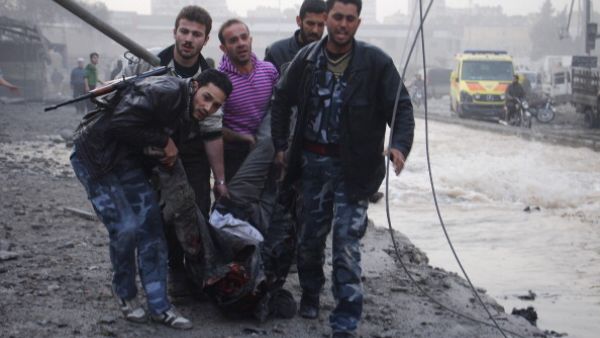 Rebels and civilians carry the body of a man killed after an air strike by pro-government forces on the Syrian city of Aleppo on November 28, 2013. [AFP]