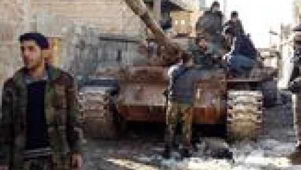 Government forces chat near a tank near the Shia villages of Nabbul and Zahra in Syria's northern Aleppo province which have been under siege by Daesh for three years on February 2, 2016. (AFP/George Ourfalian)