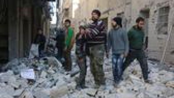 A Syrian man comforts a boy amid the rubble of buildings following a reported airstrike on the rebel-held neighborhood of al-Kalasa in Aleppo, on February 4, 2016. (AFP/Thaer Mohammed)