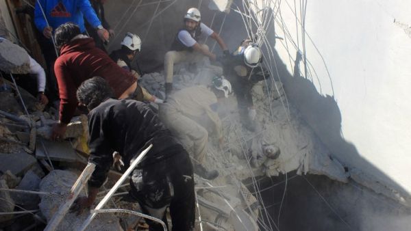 Members of the civil defence pull a boy out from under the rubble of a building following air strikes by suspected Russian warplanes backing the Syrian government on the Sahour neighbourhood of the northern Syrian city of Aleppo on February 16, 2016. (AFP/Thaer Mohammed)
