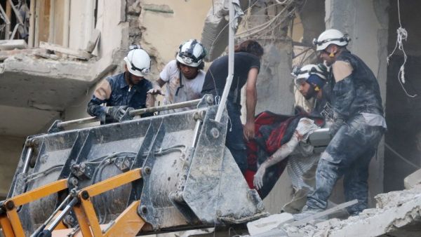 Syrian emergency personnel remove the body of a man from the rubble of a damaged building following reported air strikes on July 7, 2016, in Aleppo's rebel-held neighbourhood of Tariq al-Bab. (AFP/Thaer Mohammed)