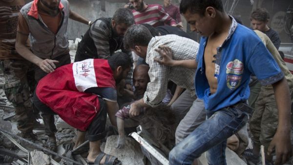 Syrians surround a man as he cries over the body of his child after she was pulled out from the rubble of a budling following government forces air strikes in the rebel held neighbourhood of Al-Shaar in Aleppo on September 27, 2016. (AFP/Karam al-Masri)