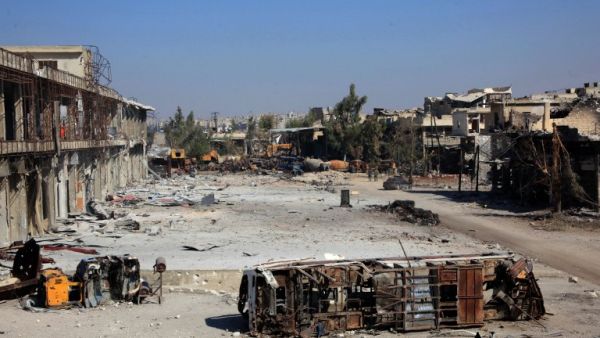 The carcass of a bus litters a bombed-out street in Ramussa on September 9, 2016, after pro-regime fighters took control of the strategically important district on the outskirts of the Syrian city of Aleppo yesterday. (AFP/George Ourfalian)