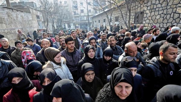 Civilians wait outside a government military police centre to visit relatives, who were evacuated from eastern Aleppo. (AFP/File)