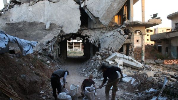 Rebel fighters fill bags with rubble from destroyed buildings they will use to strengthen a front-line position in a rebel-held area of Daraa, southern Syria, on May 18, 2016. (AFP/Mohammed Abazeed)