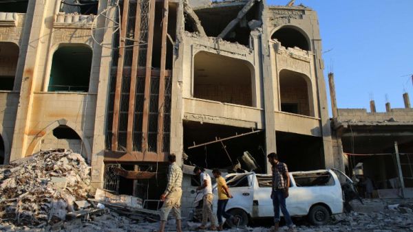 Syrians walk past a makeshift hospital in the area of Jasim in the southern province of Deraa on July 31, 2016, after it was hit in an airstrike that killed at least seven. (AFP/Mohamad Abazeed)