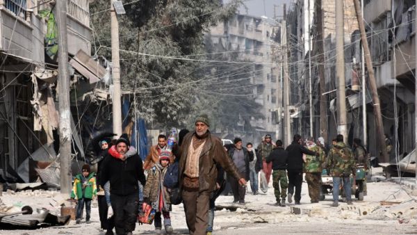 Syrian residents flee violence in Aleppo's eastern al-Salihin neighbourhood on December 12, 2016 after regime troops retook the area from rebel fighters. (AFP/George Ourfalian)