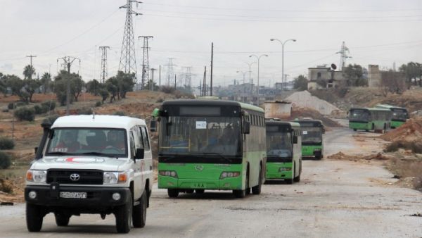 Buses sent to evacuate residents from Fuaa and Kafraya arrive at a rebel-held checkpoint on the outskirts of the two Syrian villages under rebel siege, on December 18, 2016. (AFP/Omar Haj Kadour)