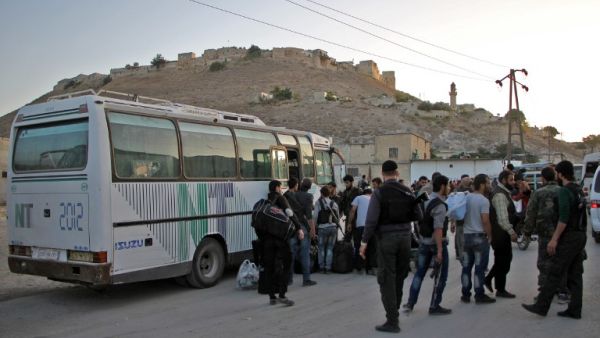 Syrian rebel fighters and their families arrive on the outskirts of Idlib, bordering the Hama province, following their evacuation from Qudssaya and al-Hamah, rebel-held neighbourhoods of the Syrian capital, on October 14, 2016. (AFP/Omar Haj Kadour)