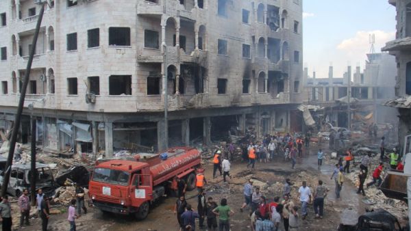 A picture taken on June 12, 2016 shows Syrian Civil Defense members, known as the White Helmets, gather at a site following air strikes on the rebel-held northwestern city of Idlib, on June 12, 2016. (AFP/Omar Haj Kadour)