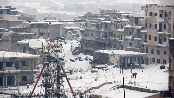 Syrians walk in a snow covered street in the town of Maaret al-Numan, in Syria's northern province of Idlib, on December 22, 2016. (AFP/Ghaith Omran)
