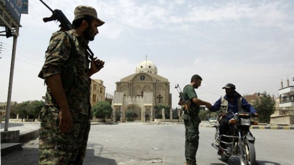 Members of the Kurdish police patrol in the neighborhood of Al-Masaken in the northeastern Syrian city of Hasaka during ongoing fighting with regime forces on August 22, 2016. (AFP/Delil Souleiman)