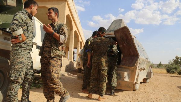 US-backed Kurdish and Arab fighters chat as they advance into the Islamic State (IS) jihadist's group bastion of Manbij, in northern Syria, on June 23, 2016. (AFP/Delil Souleiman)