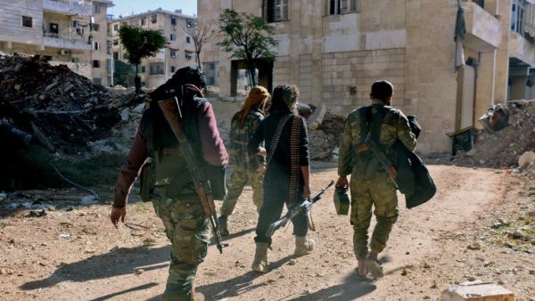 Rebel fighters walk down a street west of the northern Syrian city of Aleppo on December 9, 2016. (AFP/Thaer Mohammed)