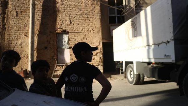 Syrian boys stand next to an Arab Red Crescent lorry carrying humanitarian aid in the rebel-held town of Douma, east of the Syrian capital Damascus, on October 19, 2016. (AFP/Abd Doumany)