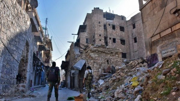 Syrian pro-government forces walks past rubble in old Aleppo's Jdeideh neighborhood on December 9, 2016. (AFP/George Ourfalian)