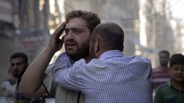Syrians react as the bodies of children are pulled from the rubble of a budling following government forces air strikes in the rebel held neighbourhood of Al-Shaar in Aleppo on September 27, 2016. (AFP/Karam al-Masri)