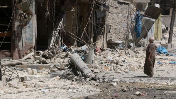 A resident of the Tariq al-Bab neighborhood of Aleppo, inspects the damage caused by reported air raids that targeted rebel-held areas in the northern city on August 16, 2016. (AFP/Thaer Mohammed)