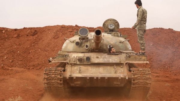 Syrian rebel-fighters from the National Liberation Front (NLF) secure a tank, part of heavy weapons and equipment withdrawn yesterday from a planned buffer zone around Idlib. (OMAR HAJ KADOUR / AFP)