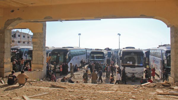 Civilians from besieged government-held villages Fuaa and Kafraya wait to be handed over from opposition to government forces near Aleppo, April 19 2017. (AFP/Omar Haj Kadour)