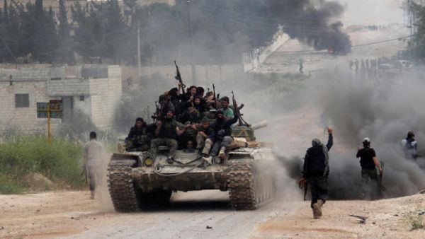 Fighters from a coalition of Islamist forces celebrate after taking the al-Mastumah base in the Syrian city of Idlib (AFP/ File)
