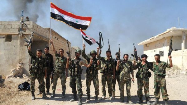 Syrian army units and pro-government forces deploying at an undisclosed location in the Atshan village in Hama. (AFP/File)