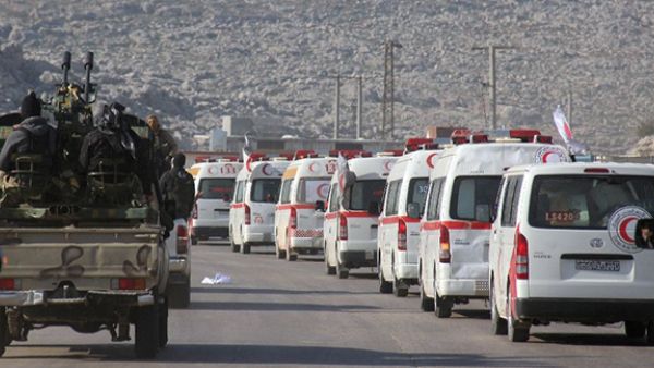 A convoy of ambulances transporting wounded civilians and rebels from the villages of Fuaa and Kafraya, the last two regime-held villages in Idlib province, is guarded as it heads towards the Cilvegozu crossing with Turkey on December 28, 2015 (AFP Photo/Omar Haj Kadour)