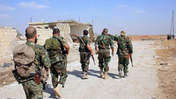 Syrian regime soldiers walk down a road in an area around Kweyris military airport, in the eastern Aleppo. (AFP/ File)