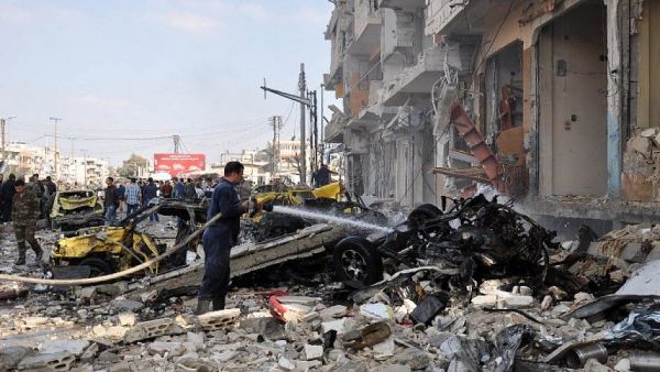 Syrian firefighters spray water on burning car at the site of a double car bomb attack. (AFP/Stringer)