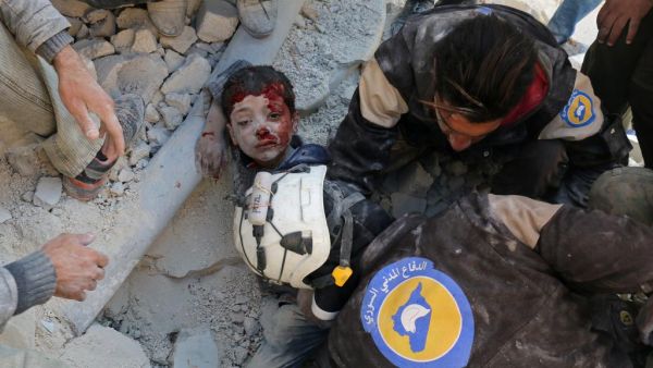 The White Helmets, Syrian civil defence volunteers, rescue a boy from the rubble in Aleppo last month. (Ameer Alhalbi / AFP)