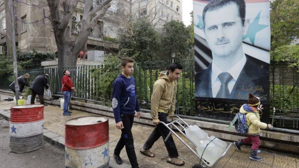 Syrians fill plastic containers with water at a public fountain in the capital Damascus on January 3, 2017. (AFP/Louai Beshara)