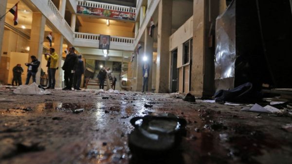 Syrian security forces and journalists stand inside the old palace of justice building in Damascus following a reported suicide bombing on March 15, 2017. (AFP/Louai Beshara)