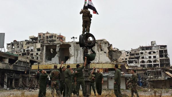 Syrian government fighters raise the country's flag after a previous evacuation of opposition fighters in 2014. (AFP)   Syrian government fighters raise the country's flag after a previous evacuation of opposition fighters in 2014. (AFP)