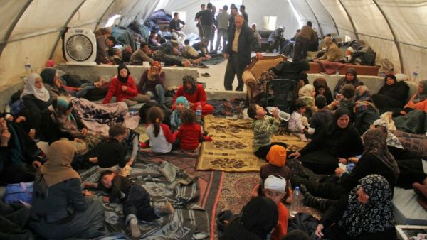 Syrians, who were injured in a suicide car bombing that targeted buses carrying evacuees from besieged government-held towns, sit in a tent on the Syrian-Turkish border in Idlib province on April 17, 2017. (AFP/Omar Haj Kadour)
