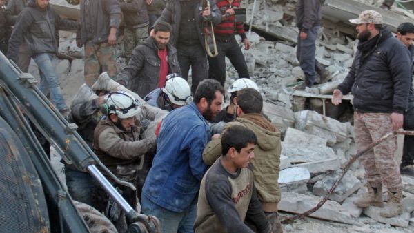 Syrian civil defense volunteers carry a wounded man following a reported airstrike by government forces, in the Syrian town of Binnish, on the outskirts of Idlib, on January 12, 2017. (AFP/Omar Haj Kadour)
