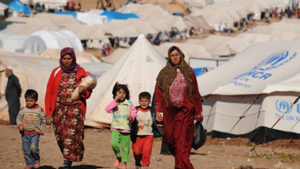 Syrian internally displaced people walk in the Atme camp, along the Turkish border in the northwestern Syrian province of Idlib. (AFP/ File)