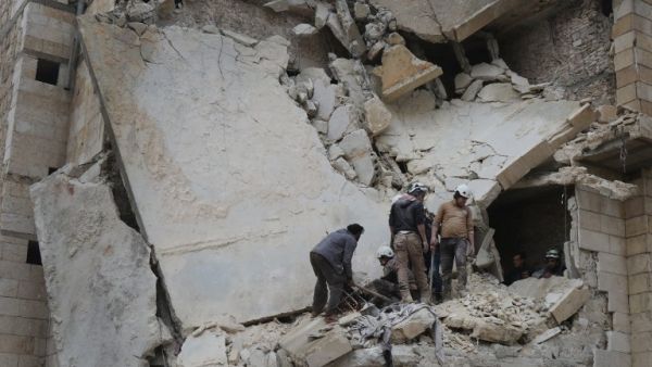 Syrian men and Civil Defence volunteers, also known as the White Helmets, search for survivors amid the rubble of a building following an air strike on the village of Maaret al-Numan, in the country's northern province of Idlib, on January 7, 2017. (AFP/Mohamed al-Bakour)