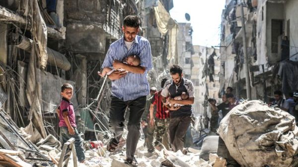 June 9, 2016 – Syrian rescue workers and citizens in Aleppo evacuate people from a building following a barrel bomb attack by Syrian government forces on the rebel held Al-Fardous neighborhood of the northern city of Aleppo. (AFP / AMEER ALHALBI)